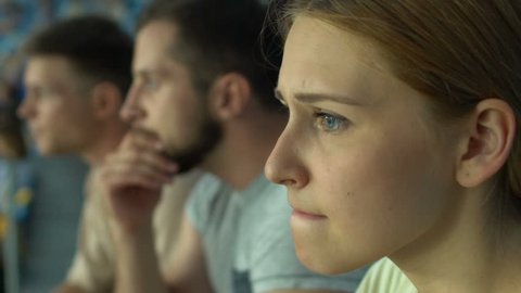 Girl fan with friends watching sport game or races at stadium, worried, anxious