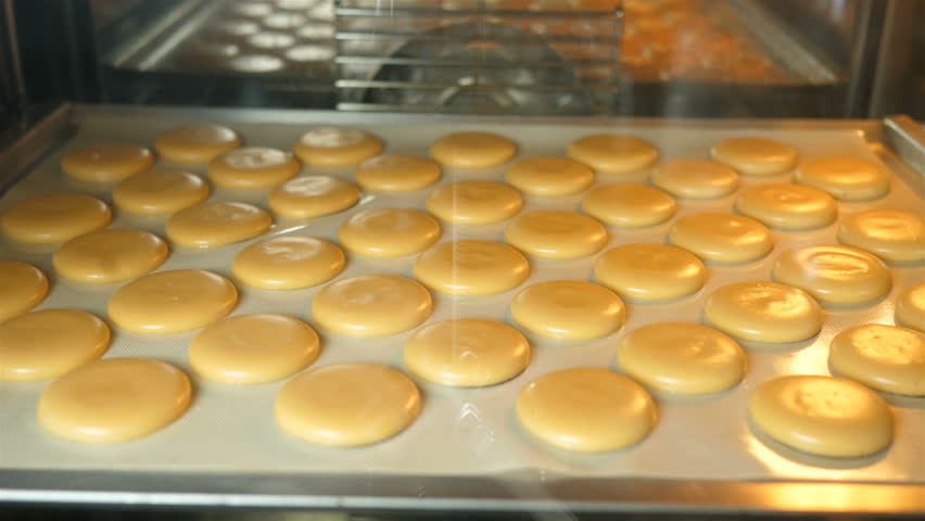 Macaroons will talk in the oven in a professional kitchen. Accelerated cooking process hd. | Shutterstock HD Video #1017801832