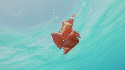 Underwater Slow Motion Shot Of A Decaying Red Plastic Bag Floating By. Environmental Pollution Of The Sea. : vidéo de stock