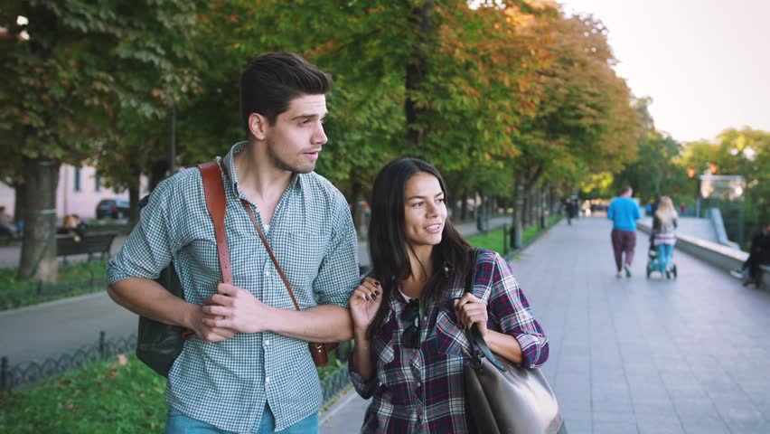 Young mixed race tourist couple walking through the city and having some fun, slow motion