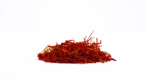 Red saffron pile. Rotating on the turntable. Isolated on the white background. Close up. Macro.