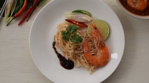 Boiled noodles with shrimp  on white plate and wood table.