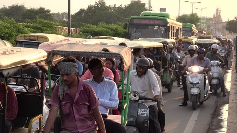 NEW DELHI, INDIA - SEP 8: Auto rickshaws, push bikes and pedestrians in heavy traffic scene on bridge on September 8, 2018 in New Delhi, India 