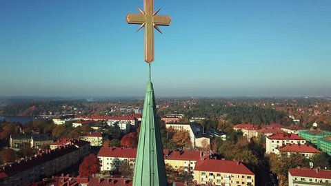 Aerial footage of a church tower with a golden christian cross on top in Stockholm, Sweden