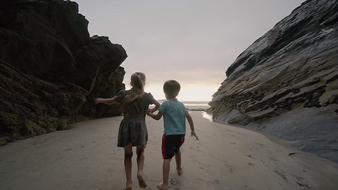 Kids exploring the beaches of Newquay Coast around Cornwall South West England UK