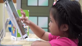 little asian girl playing with games wireless tablet