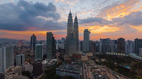 Time lapse: Aerial cityscape view during dusk overlooking the Kuala Lumpur city center skyline and construction area at sunset in Malaysia. Day to night. High Quality 4K