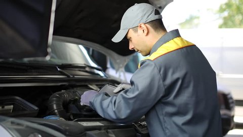 Auto mechanic changing motor oil