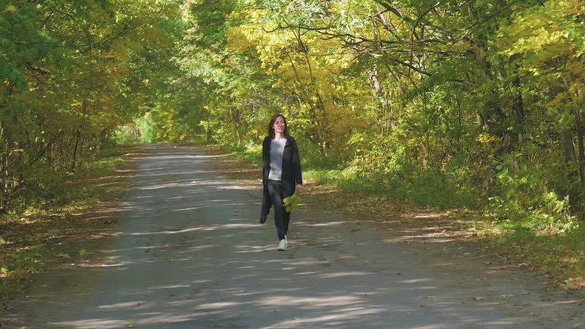 Beautiful girl walking in the autumn park.