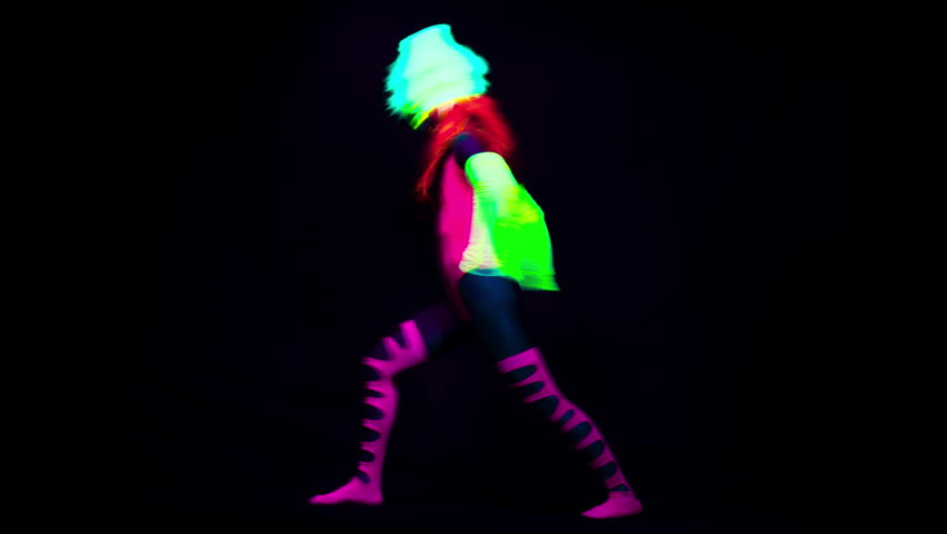 Amazing female yoga instructor moving between poses wearing fluorescent clothing under UV black light | Shutterstock HD Video #1017873925