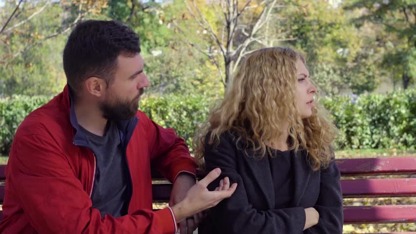 Couple arguing on a bench in a park