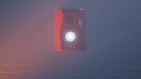 Sound and strobe red fire alarm mounted to a wall as part of the fire alarm system. Flashing bright light, alarm is activated during a fire in the room. Alert in case of dangerous situation.
