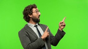 young crazy businessman pointing to an empty place against chroma key background, ready to be cropped