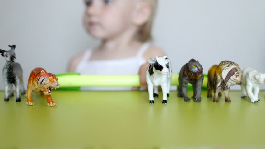 Parents teach a small child to distinguish between animals, a child