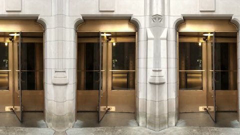 An endlessly looping wall of golden revolving doors on a gothic stone building.  	