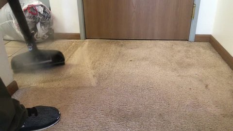 Carpet cleaner steams high traffic entry way area with wand before suctioning thereafter.  