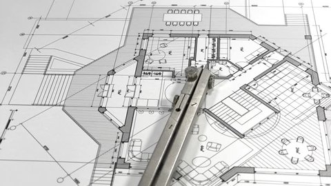 Blueprints - architectural drawings and compasses smoothly rotate on the surface of the architectural plan of a modern house