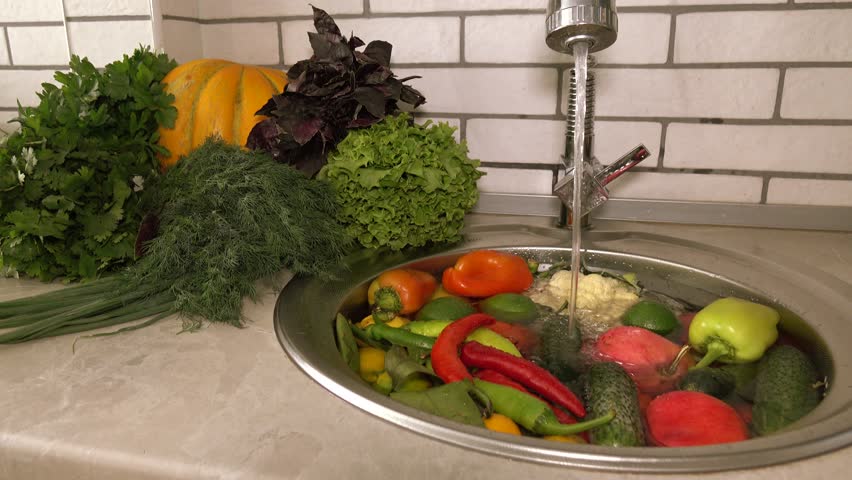 Fresh vegetables and fruits in the sink under running water, tomatoes and cucumbers, pepper and dill large. Cleaning vegetables from pollution and toxic chemicals. Royalty-Free Stock Footage #1017928933