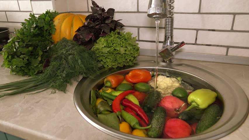 Fresh vegetables and fruits in the sink under running water, tomatoes and cucumbers, pepper and dill large. Cleaning vegetables from pollution and toxic chemicals. Royalty-Free Stock Footage #1017928942