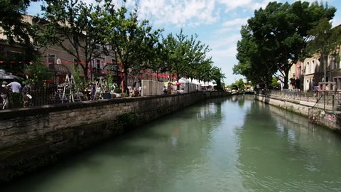 L'Isle-Sur-La-Sorgue, France / France - 08 14 2018: Banks of the La Sorgue river on L'Isle-Sur-La-Sorgue. On one side are the stands of the antique fair that is held every August, on the other, you ca