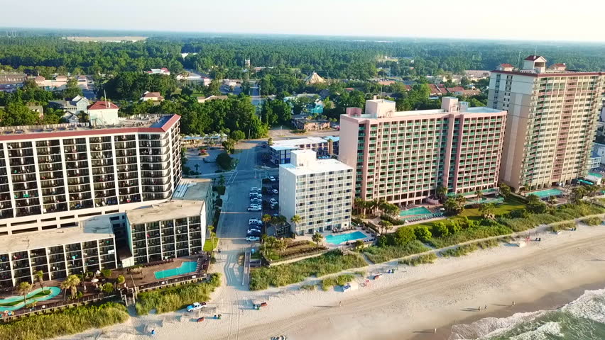 Aerial view of the hotels next to Myrtle Beach, showing the waves and sandy beach.