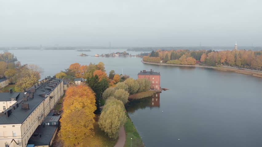 Aerial view of Lapinlahti Hotel and Hospital Helsinki Finland. Autumn with yellow and green colorful trees. Cloudy and calm daytime scene. Drone flying forward.
