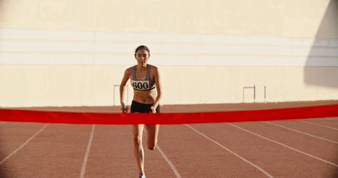 Female athlete on track. Young asian runner runing on track of stadium, jumping over barriers, then crossing the finish line preparing for competition 4k