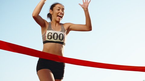 Female athlete on track. Young asian runner runing on track of stadium, happily crossing the red finish line, getting ready for competition 4k