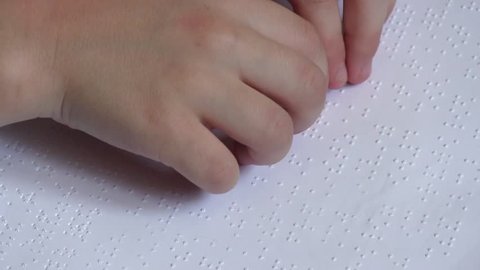 Child learning Braille alphabet at school