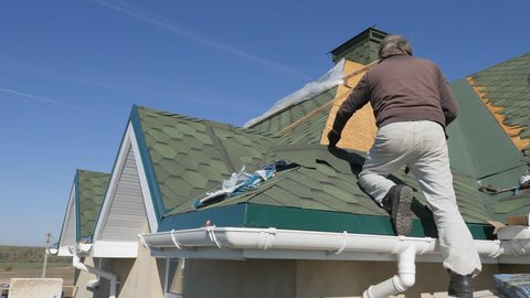soft roof of shingles. Repair of the roof of a residential house. installation of soft tiles. partial replacement of the damaged roof. Dot repair. Nailing roofing material to the surface of the