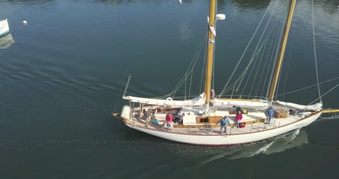 Rockport, Maine / United States - 09 22 2017: ROCKPORT, MAINE, SEPTEMBER 2017 - Sailboat with sailors heading out to sea from Rockport Harbor.
