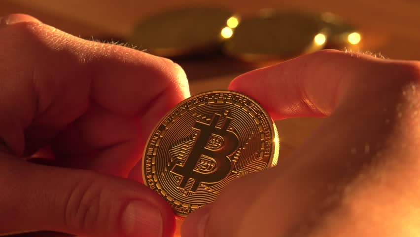 Woman holding a gold bitcoin in his hands. Glare of the sun. 4K, UHD, 50p, Cinematic,Closeup, 						 | Shutterstock HD Video #1018003126