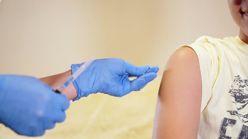 Doctor injecting flu vaccine to patient's arm in local hospital. coronavirus vaccine