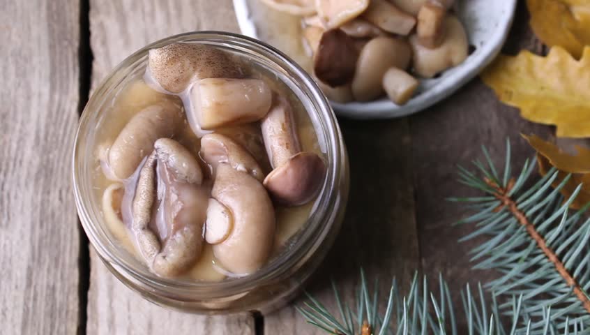 Forest mushrooms marinated on a plate on a wooden background, selective focus.