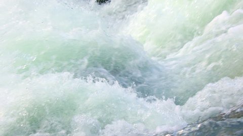 Super slow motion view of clean fres raging water in mountain river