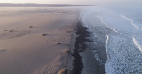 4K aerial fly over view of tourists camping on the shoreline of the Atlantic Ocean,Skeleton Coast,Namibia