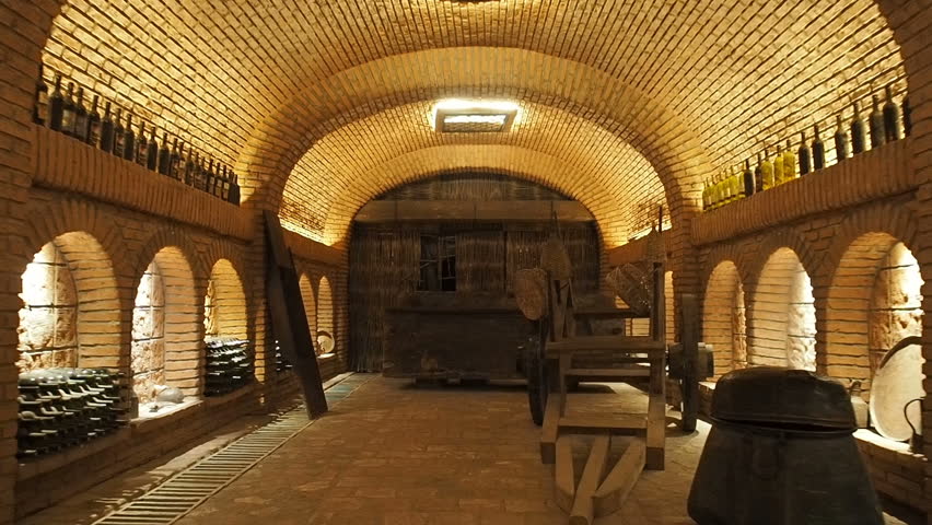 Large wine cellar interior.  High quality georgian red wine bottles. Wine making industry. Wines tasting shop. Storage for wine bottles and barrels Royalty-Free Stock Footage #1018018792