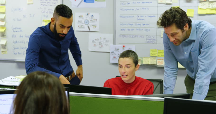Executives discussing on desktop pc at desk in office 
