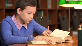 Footage portrait of schoolboy doing their homework in library or room. 4k education video