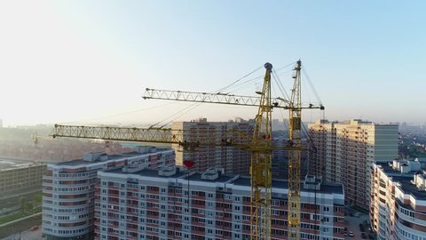 Construction cranes on the background of buildings.