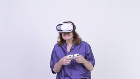 Happy senior man playing games while using virtual reality headset