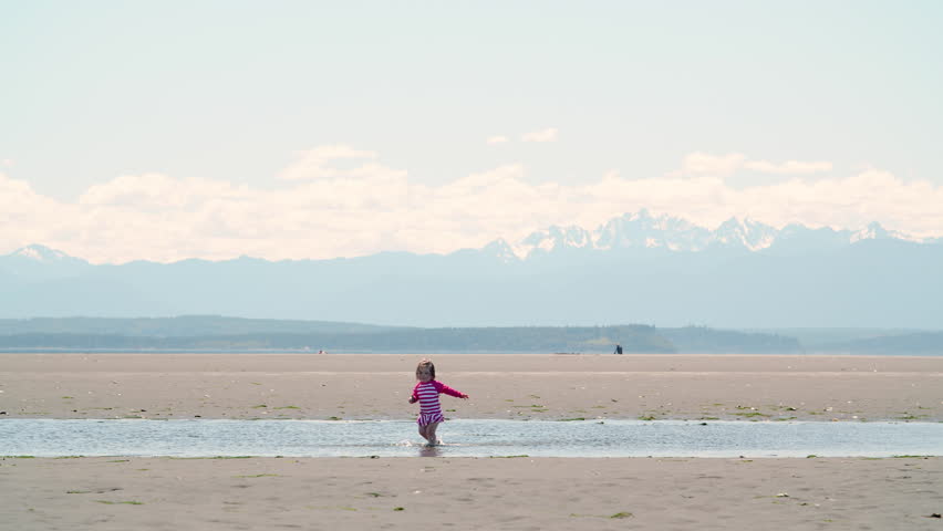 Toddler in Washington Beach Tide Flats with Mountains Background