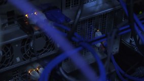 From below closeup view of glowing indicators of server hardware in racks with blue cables - Powered by Shutterstock - Get 15% off with code: PIKWIZARD15