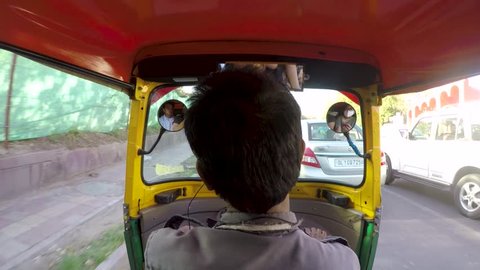 new delhi, Delhi / India - 06 24 2018: Footage of an auto rickshaw shot from the back seat running through traffic.