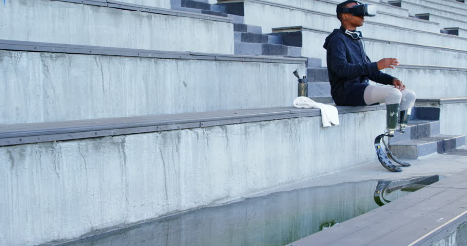 Disabled athletic using virtual reality headset at sports venue 4k