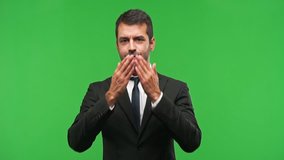 Businessman on green screen chroma key background covering eyes by hands. Surprised to see what is ahead