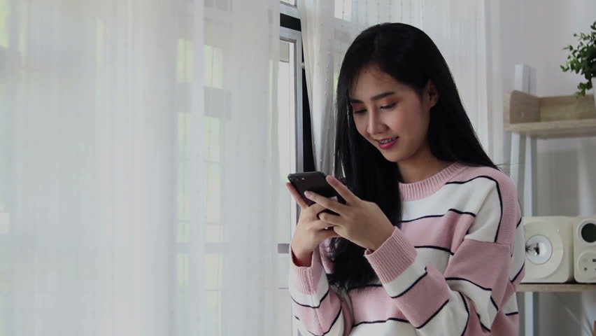 Young asian women are playing there smartphone. Portrait of asian woman playing smartphone on the white background.