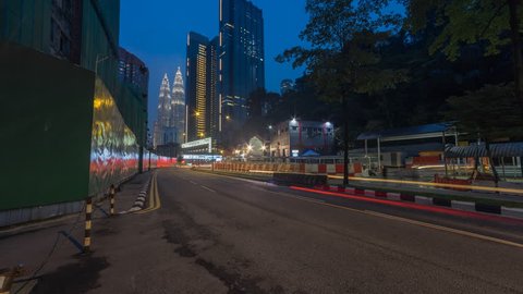 Time lapse of day to night of a busy cityscape street view in Kuala Lumpur, Malaysia at sunset with light trails and motion blur. Slide up motion timelapse. High Quality, Pro res Full HD.