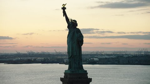 Aerial view of orbiting the Statue of Liberty to downtown Manhattan close to night. Wide shot. 4k shot with a RED camera.