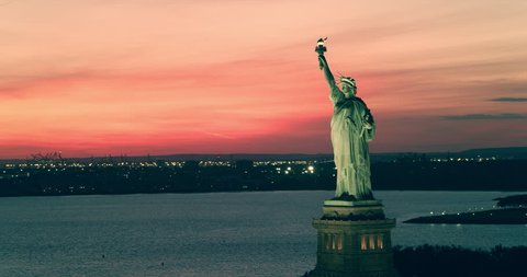 Aerial view of the Statue of Liberty orbiting   at sunset, New York City, during summer. Best New York aerial shot. Wide shot. 4k shot with a RED camera. 